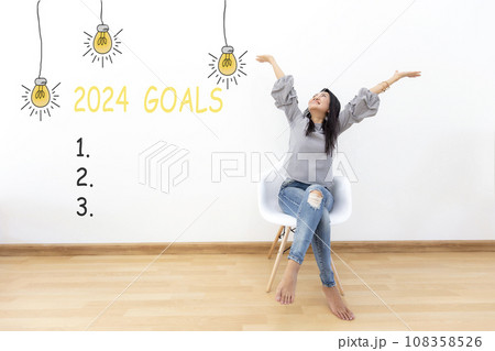 2024 goals with young woman cheerful and happy new year on the chair. 108358526