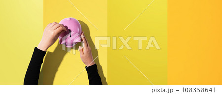 Person depositing money in a piggy bank 108358641
