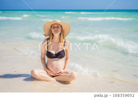Radiant and expecting, a pregnant woman stands on a pristine snow-white tropical beach, celebrating the miracle of life against a backdrop of natural beauty Radiant and expecting, a pregnant woman stands on a pristine snow-white tropical beach, celebrating the miracle of life against a backdrop of natural beauty 108359052