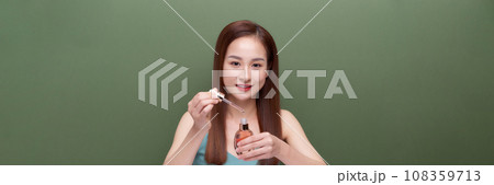 young beautiful female applying facial serum young beautiful female applying facial serum 108359713