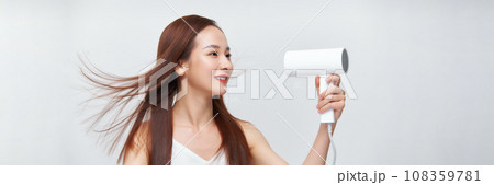 Banner of young asian woman using hair dryer on white background. 108359781