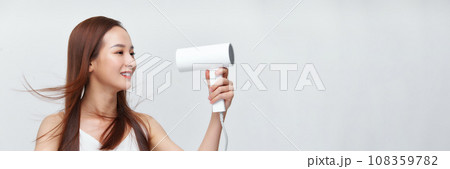 Banner of young asian woman using hair dryer on white background. 108359782