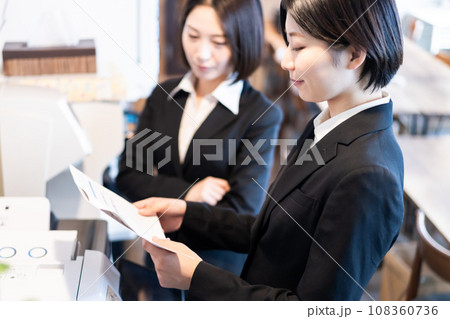 プリントしたドキュメントを確認する若い女性 108360736