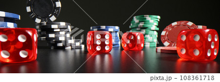 Red dice with white dots scattered on table near poker chips 108361718