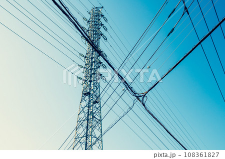 高圧送電鉄塔と交差する市街地の電線と青空　a-4 暖色寒色強調 108361827