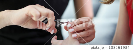 Loving mom cuts off tiny nails of little daughter at home 108361984