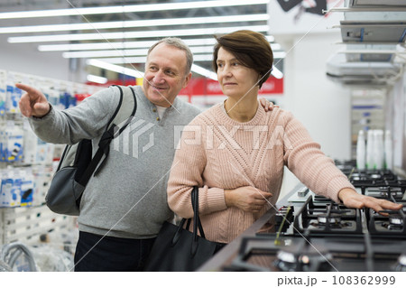 Mature couple choose a gas stove Mature couple choose a gas stove 108362999