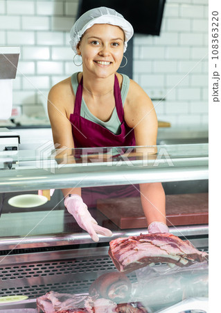 Girl seller works in specialized butcher shop Girl seller works in specialized butcher shop 108363220