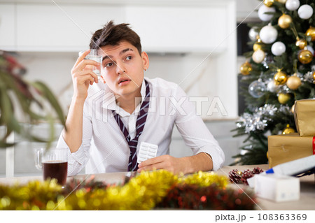 man suffering while hungover after new year party man suffering while hungover after new year party 108363369