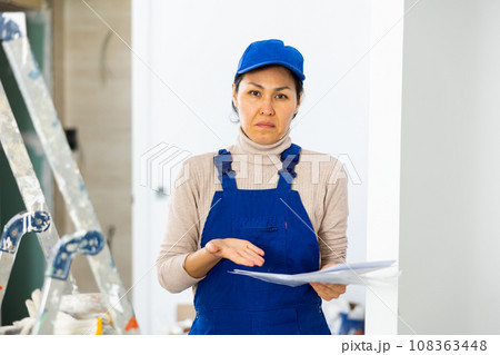 Frustrated woman builder checking project documentation Frustrated woman builder checking project documentation 108363448