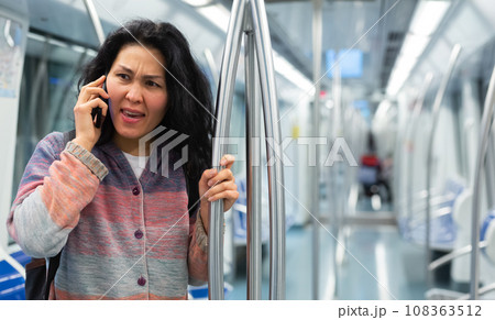 Woman having phone talk in subway car 108363512