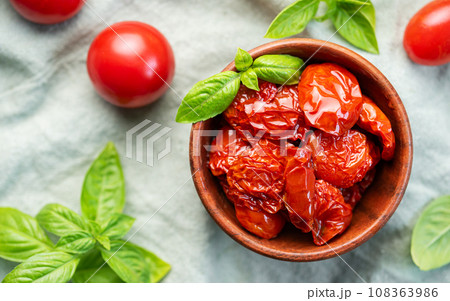 Bowl with sun dried tomatoes with fresh herbs and spices. 108363986