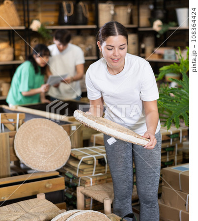 Young female interior designer choosing wickerwork in store 108364424