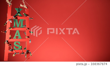 Christmas decoration ladder on red copy space background 108367874