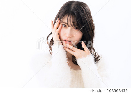 白バックでスキンケアをするニットを着たミドルの女性 108368432