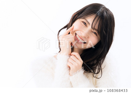 白バックでスキンケアをするニットを着たミドルの女性 108368433