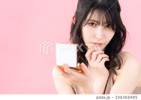 ピンクバックでスキンケアをするミドルの女性 ピンクバックでスキンケアをするミドルの女性 108368495