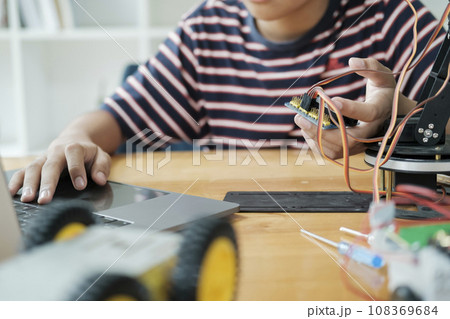 Asian teenager doing robot project in science classroom. technology of robotics programing and STEM education concept. Asian teenager doing robot project in science classroom. technology of robotics programing and STEM education concept. 108369684