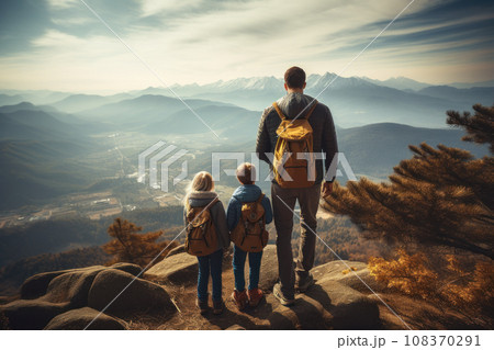 A family of travelers standing on top of a mountain A family of travelers standing on top of a mountain 108370291