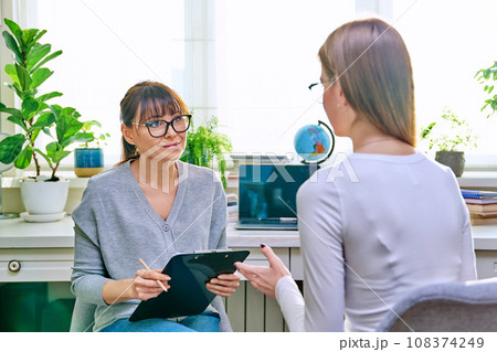 Young female at therapy meeting with psychotherapist Young female at therapy meeting with psychotherapist 108374249