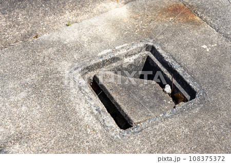 古くなって割れた排水のコンクリート桝のふた 108375372