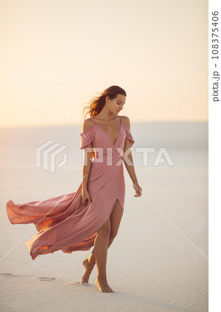 Walking in Desert Fashionable Woman Model in Evening Pink Dress Walking in Desert Fashionable Woman Model in Evening Pink Dress 108375406