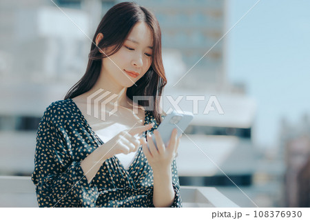 若い女性がスマホを持っているシーン 108376930
