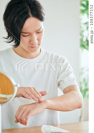 腕にクリームを塗る若い男性 腕にクリームを塗る若い男性 108377152