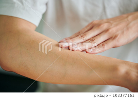 腕にクリームを塗る若い男性 腕にクリームを塗る若い男性 108377163