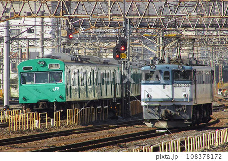 金町駅を通過する常磐線103系電車と新金貨物線EF65形 108378172