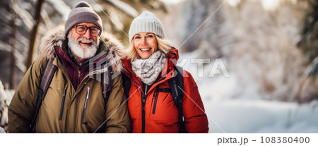 Banner with a couple of adults taking a walk through a beautiful winter forest, outdoor recreation in the forest. Free space for text, invitation to Christmas and New Year holidays in nature 108380400