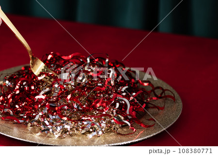 Creative New Year food, New Year party concept. Christmas tinsel on a plate like spaghetti. Creative New Year food, New Year party concept. Christmas tinsel on a plate like spaghetti. 108380771