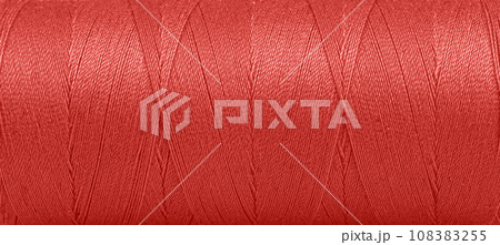 Texture of threads in a spool of red color on a white background 108383255
