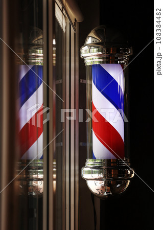 Barber shop vintage pole. copyspace Barbershop. Barber shop pole in red white and blue with lightbulb on top. Barber shop vintage pole. copyspace Barbershop. Barber shop pole in red white and blue with lightbulb on top. 108384482