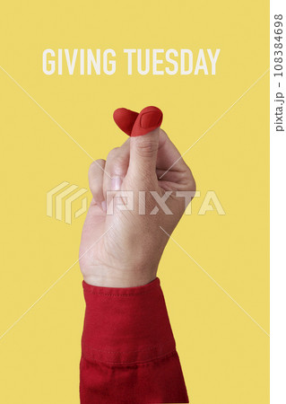 doing finger heart gesture and text giving tuesday doing finger heart gesture and text giving tuesday 108384698
