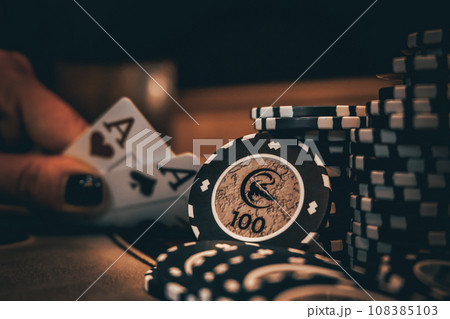 Dealer or croupier shuffles poker cards in a casino on the background of a table, chips. Concept of poker game, game business. Playing for money, a big win, a jackpot, gambling, a desire to get rich. 108385103