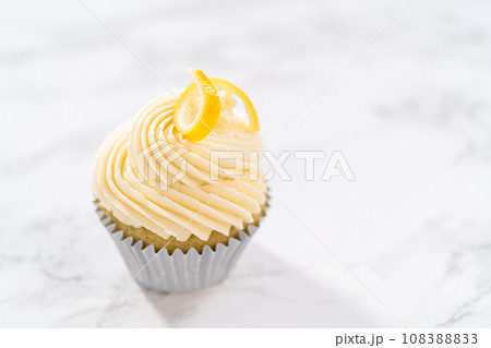 Lemon cupcakes with lemon buttercream frosting, and decorated with lemon swist. 108388833
