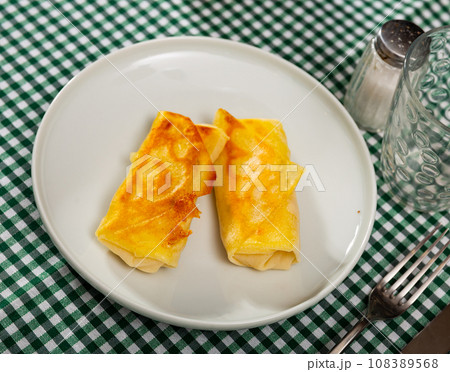 Pancakes stuffed with sweet berry chocolate filling are served with cup of hot green tea 108389568