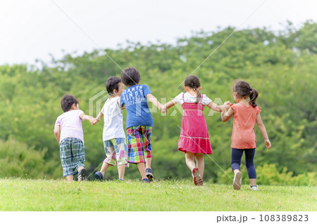 公園の草地で遊ぶ小学生たちの後ろ姿 公園の草地で遊ぶ小学生たちの後ろ姿 108389823