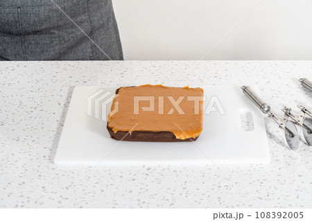 Scoring caramel fudge using a wheel dough cutter for cutting into small square pieces. Scoring caramel fudge using a wheel dough cutter for cutting into small square pieces. 108392005