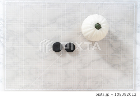 Flat lay. Making ears from black clay to make panda pumpkin for Halloween. Flat lay. Making ears from black clay to make panda pumpkin for Halloween. 108392012