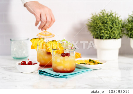Step by step. Garnishing unset cocktail garnished with a slice of fresh orange and pineapple. Step by step. Garnishing unset cocktail garnished with a slice of fresh orange and pineapple. 108392013