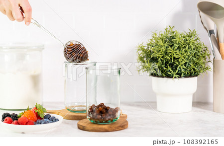 Pouring freshly made mixed berry boba smoothie into a drinking glass. Pouring freshly made mixed berry boba smoothie into a drinking glass. 108392165
