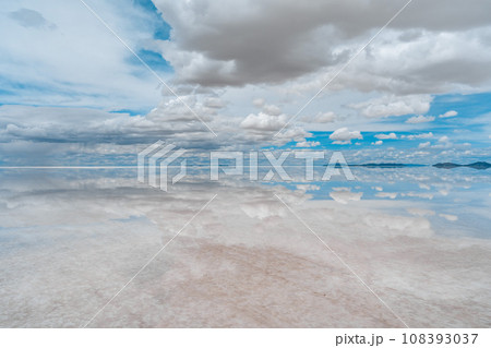 世界一の絶景雨季のウユニ塩湖の上下に反射する青と白の世界 108393037