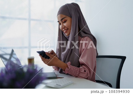 Muslim female employee Using the phone to talk to customers in the office Muslim female employee Using the phone to talk to customers in the office 108394930