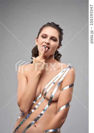 Daring topless woman liking her middle finger Daring topless woman liking her middle finger 108395047