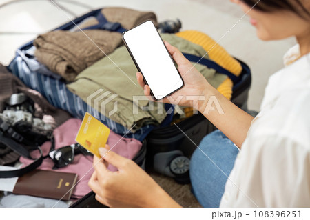 Happy young woman with credit card booking vacation at travel agency or making hotel reservation online. mockup mobile 108396251