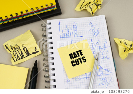On the table there is a notepad with notes and sticky notes with the inscription - Rate cuts On the table there is a notepad with notes and sticky notes with the inscription - Rate cuts 108398276