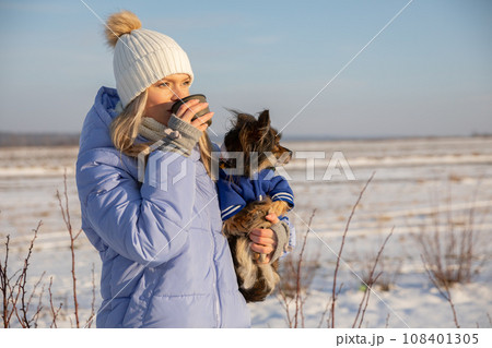 The dog and its owner visible against the winter landscape. 108401305