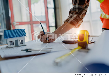 engineer brainstorming and measuring for cost estimating on blueprint and floor plan drawings about design architectural and engineering for houses and buildings. engineer brainstorming and measuring for cost estimating on blueprint and floor plan drawings about design architectural and engineering for houses and buildings. 108401383